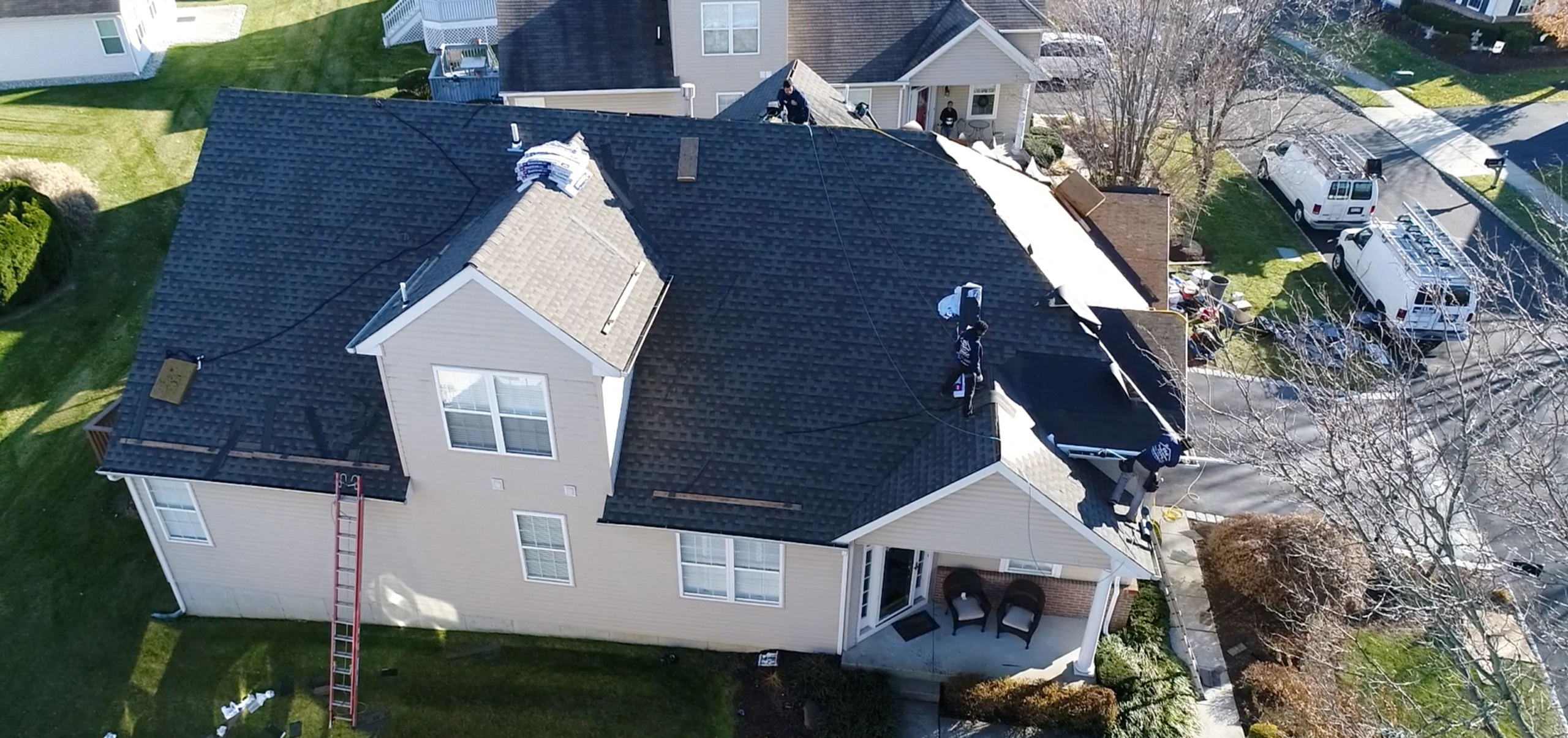 A roofer and a customer talking outside of a house.